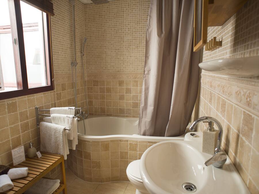 Un baño con bañera, lavabo y ducha.