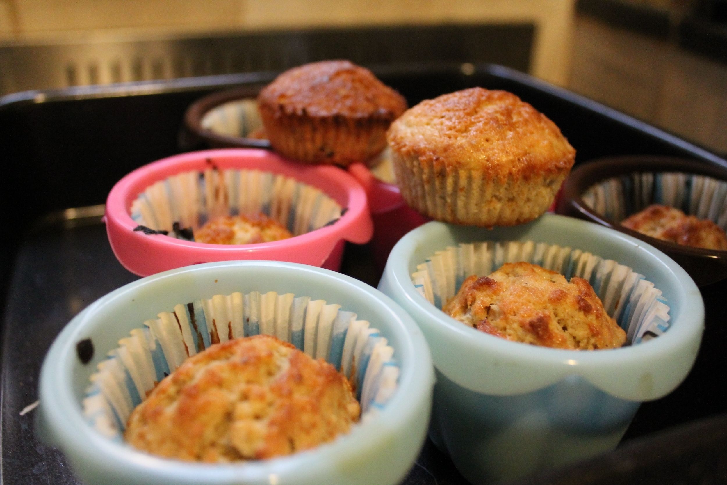 A tray with several muffin cups containing muffins.
