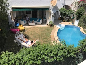 Un pati amb piscina, mobiliari exterior i una cadira espanyola.