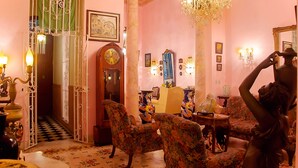 A room with a checkered floor, a large chandelier, and a clock on the wall. - Hostal D' Cordero (Santa Clara)