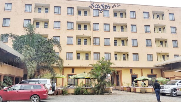 A hotel with multiple floors, balconies, and outdoor seating areas with umbrellas. - Sagas Hotel Ltd (Nairobi)