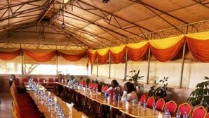 A long table with chairs arranged for a meeting or conference in a tented area. - Sagas Hotel Ltd (Nairobi)