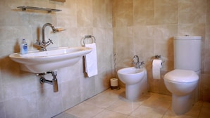 A bathroom with a sink, bidet, toilet, and a mirror. - Goodenough Guesthouse (London)