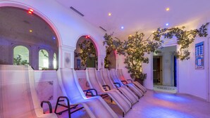 Eine Reihe von Massagekörpern in einem Spa-Bereich mit Bögen und einer Baumdekoration.