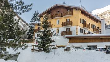 A multi-story hotel with balconies and a snow-covered roof.