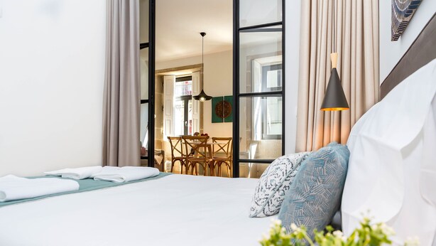 Habitació d'hotel amb un llit, una taula de menjador i un llum penjant.