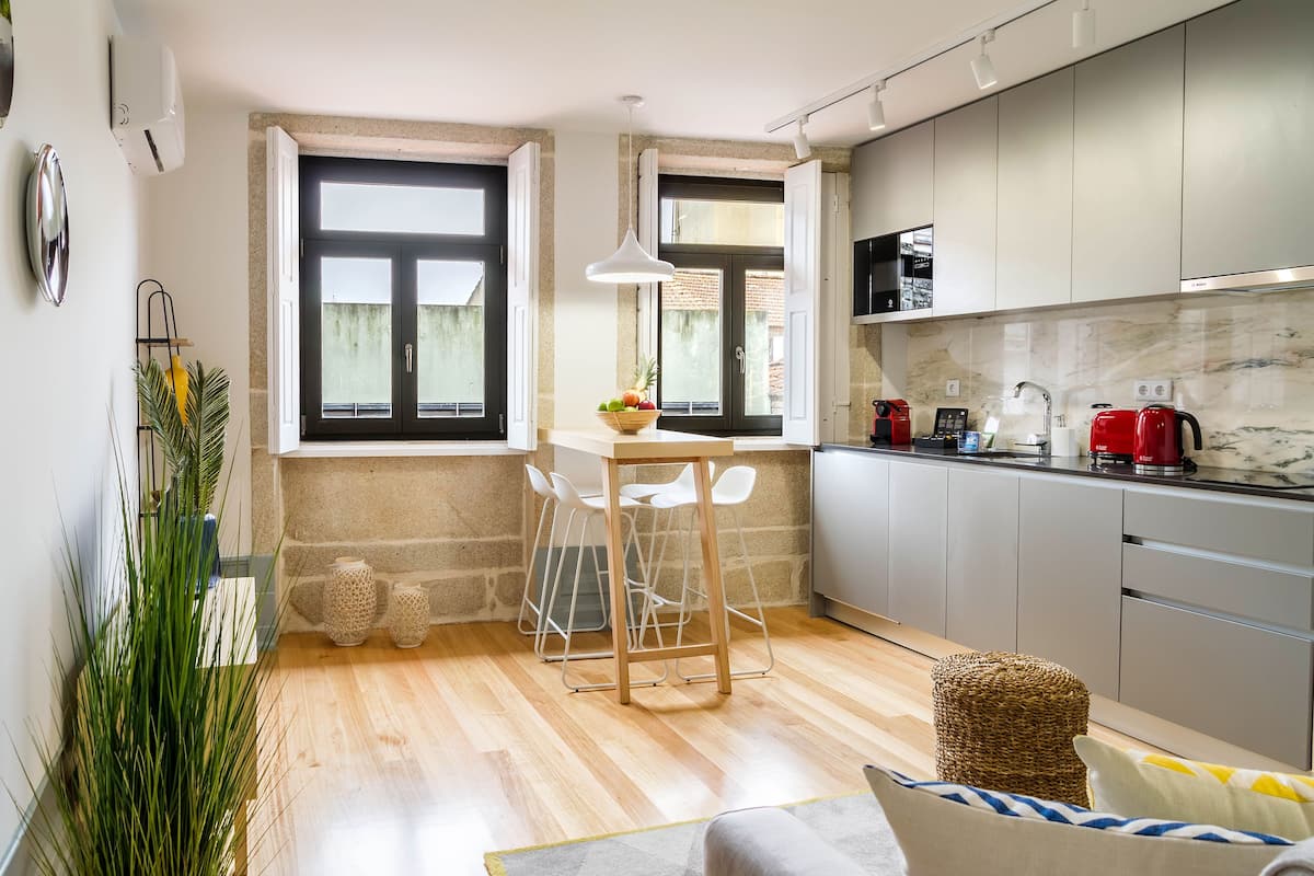 A compact kitchen with a dining area, a large window, and a view of the outside.