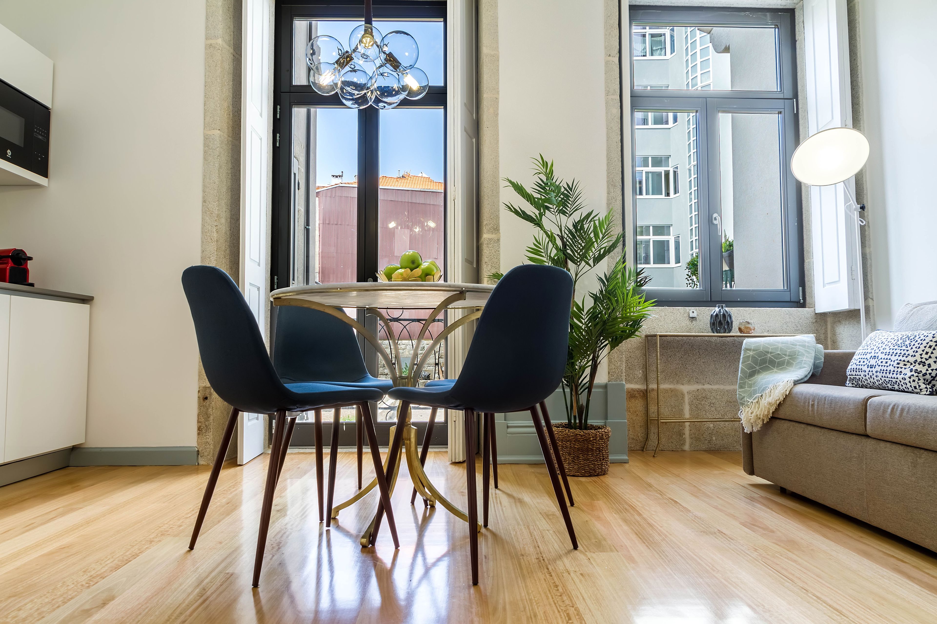 Una cocina moderna con una mesa de comedor, sillas y una planta en maceta.