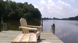 A wooden dock with a bench and a wooden post with a light fixture. - Marvel's on the Creek (East New Market)
