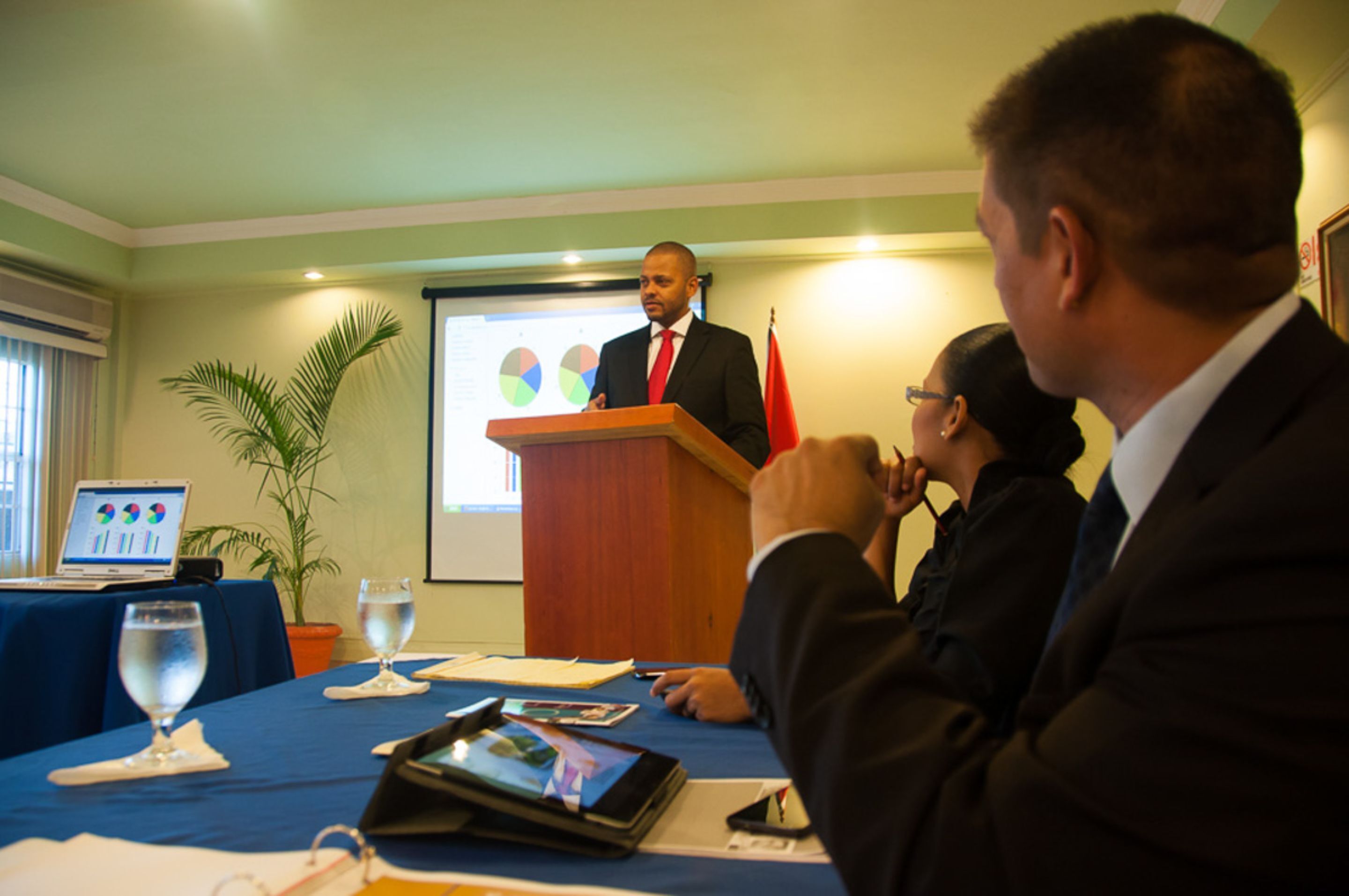 A conference room with a podium, a laptop, and a presentation screen.