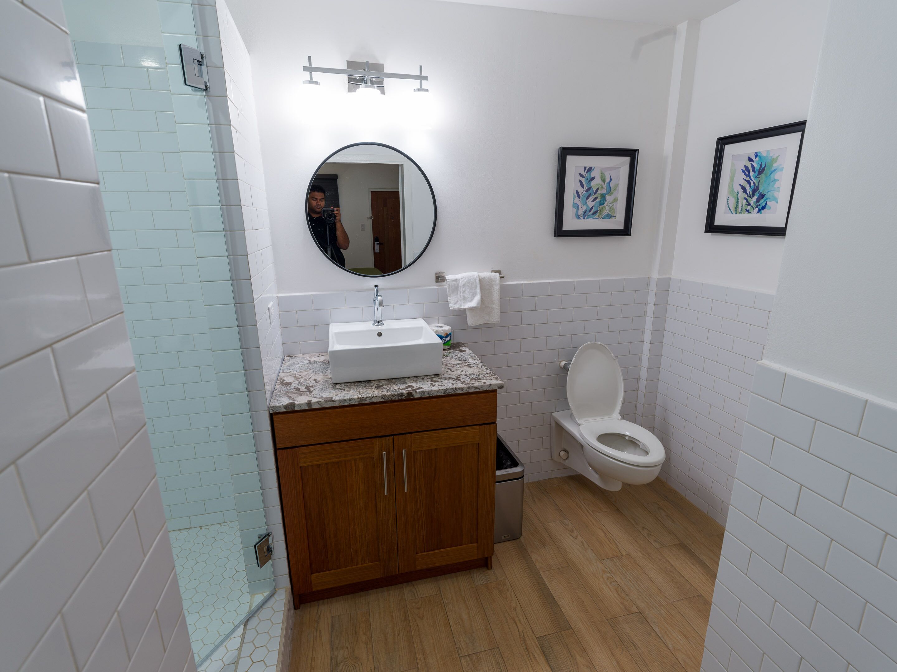 Een badkamer met een wastafel, spiegel, toilet en houten kastjes.