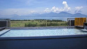 Une piscine extérieure moderne offrant une vue dégagée sur les montagnes et un paysage verdoyant.