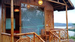 Une structure en bambou dotée d’un balcon et d’une grande fenêtre.
