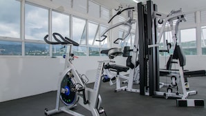 A gym with exercise equipment, large windows, and a view of the city. - Brompton 40 by Pro Homes Jamaica (Kingston)