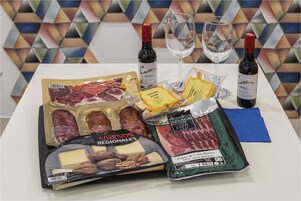 Una mesa con diferentes alimentos y dos botellas de vino.