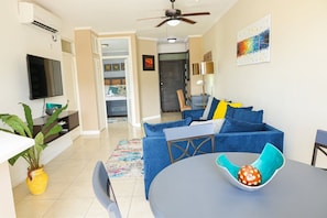 Relax in this stylish living space with a sofa, dining table, and kitchenette.