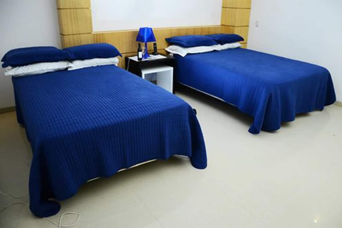 Habitación con 2 camas individuales, varias camas | Minibar, caja fuerte, cortinas opacas y tabla de planchar con plancha