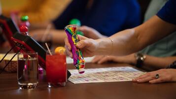 A person pouring a colorful drink from a bottle into a glass.