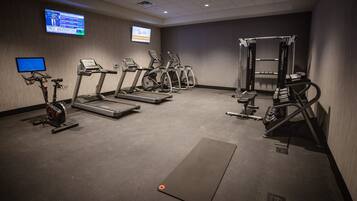 A gym with treadmills, elliptical machines, and weightlifting equipment.