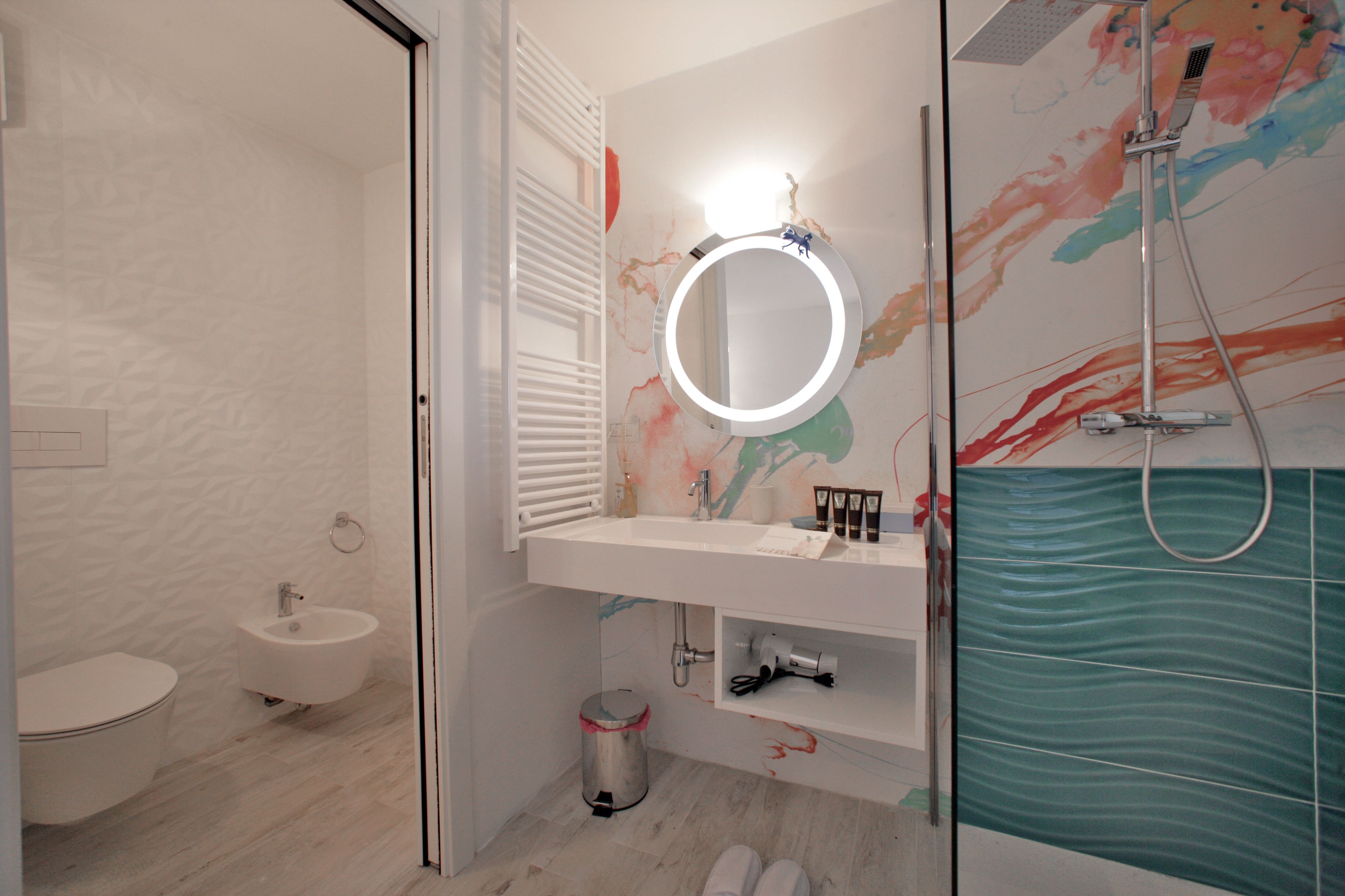 Une salle de bain moderne équipée de toilettes, d’un bidet, d’un lavabo et d’une douche.