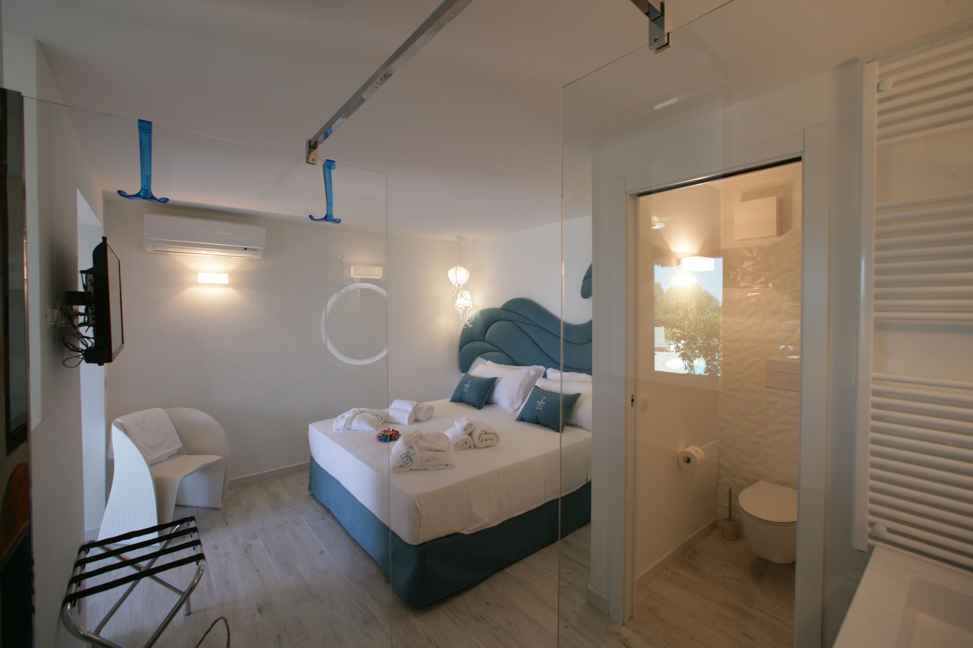 Una camera d'albergo moderna con un letto, un'area salotto e un bagno.
