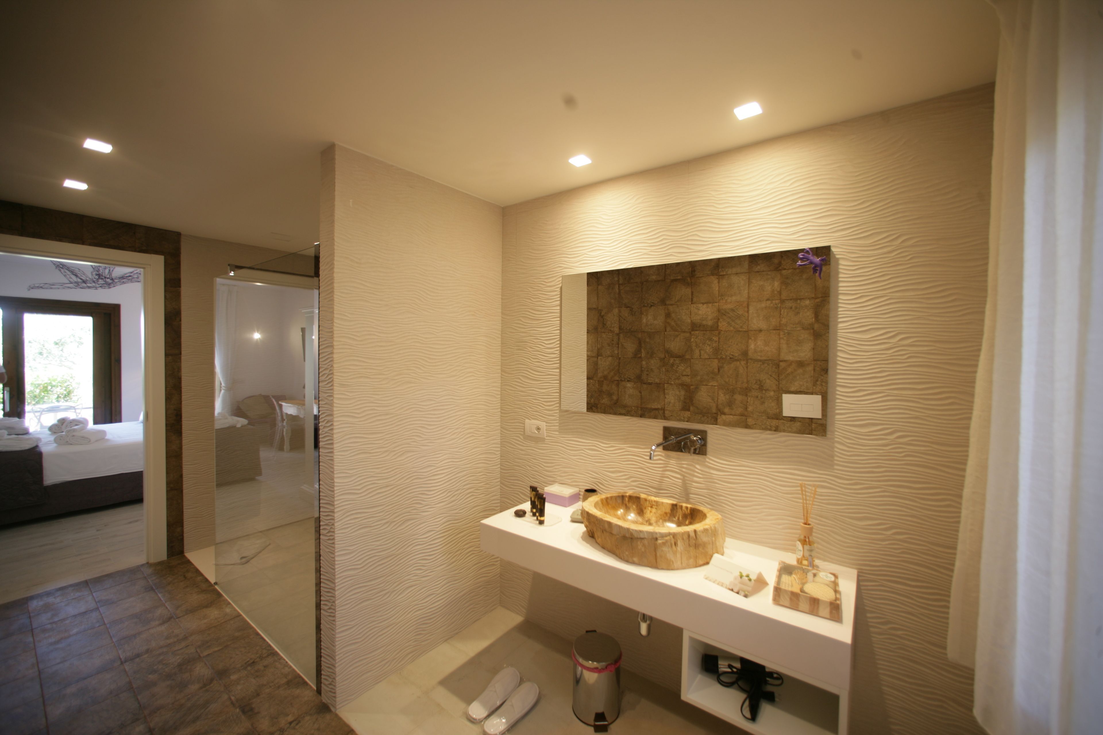 A modern bathroom with a large wooden sink, a mirror, and a glass shower enclosure.