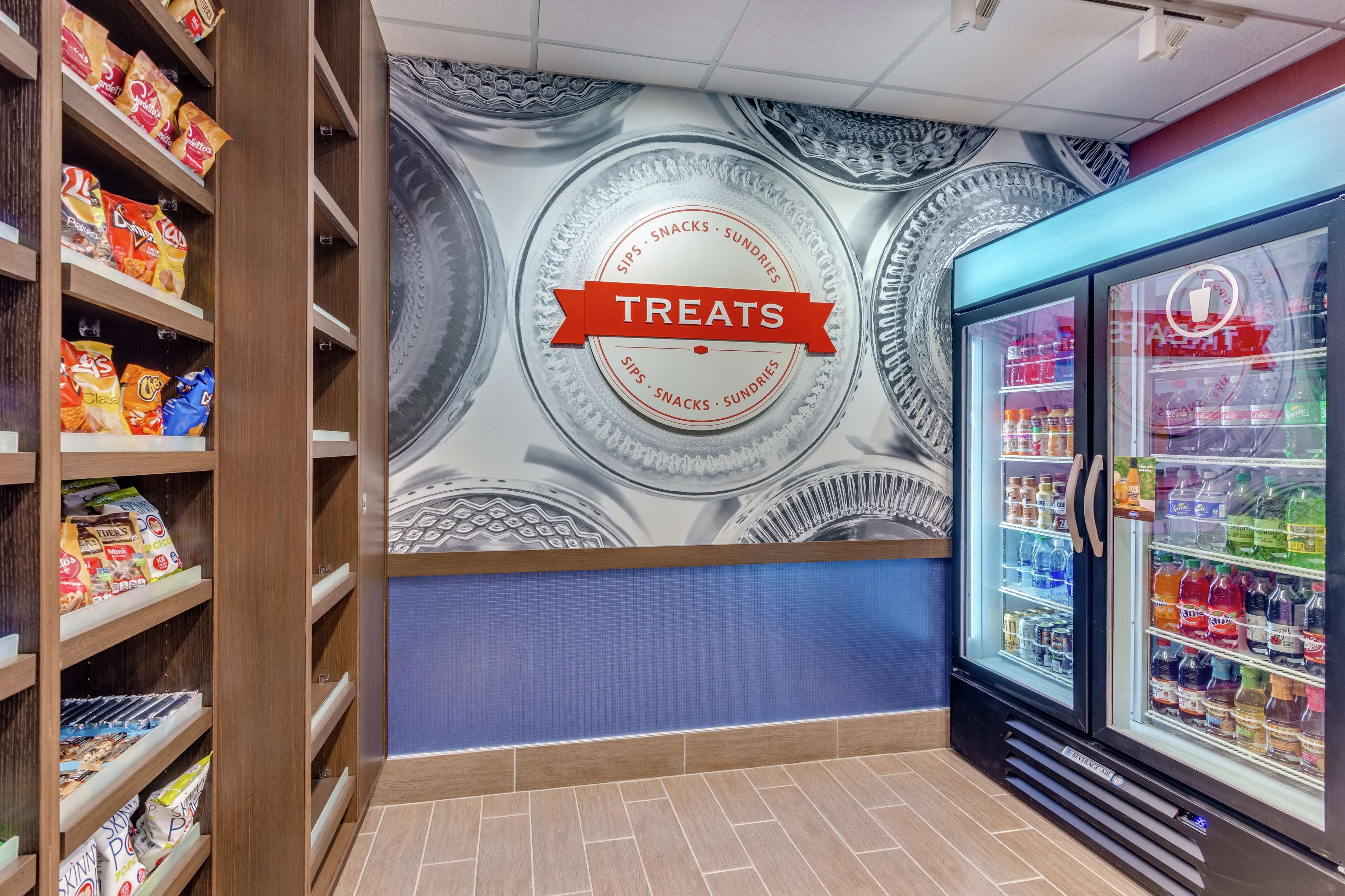 Una pared con un letrero que dice 'Treats' y estantes llenos de refrigerios.