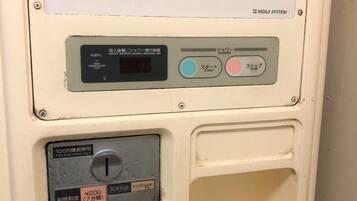 A public restroom with a sign providing usage instructions, a temperature sensor, a coin-operated button, and a timer display.