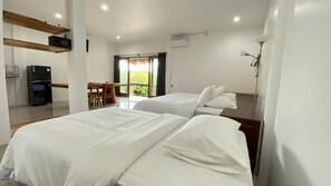 Une chambre d’hôtel avec deux lits, un bureau, une chaise et un balcon avec vue.
