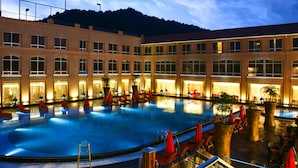 A large indoor swimming pool with multiple lounge areas and potted plants. - Easeland Hotel  Guangzhou (Guangzhou)