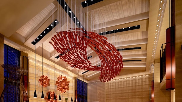 A spacious lobby with a modern design, featuring a large red abstract sculpture, elegant lighting, and a polished floor. - Easeland Hotel  Guangzhou (Guangzhou)