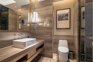 Un baño moderno con un espejo grande, un lavabo blanco y un inodoro.