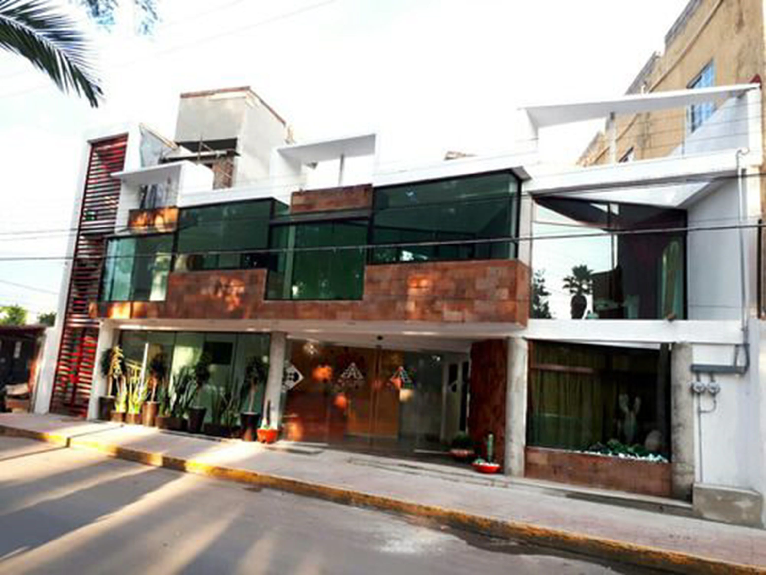 Un edificio moderno con fachada de vidrio, un muro de acento de ladrillo y un escaparate visible.