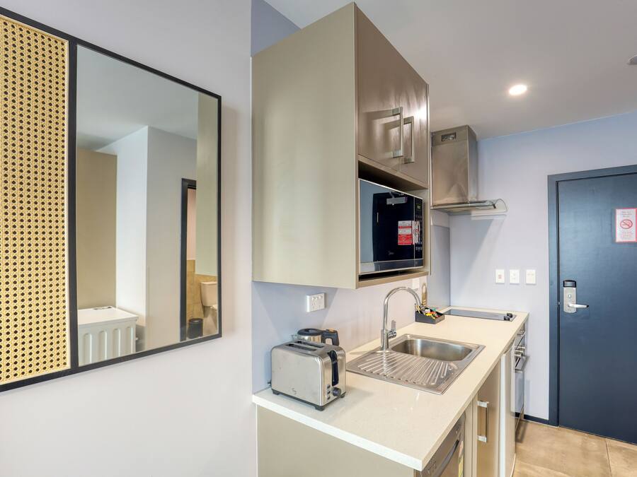 A modern kitchen with a toaster, sink, and stainless steel appliances.