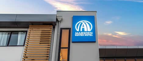 Un bâtiment moderne avec une enseigne indiquant « Marsden Suites Hotel ».