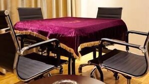 A conference room with a table covered by a purple cloth, four chairs, and a painting on the wall. - Bandao Mingzhu Hotel (Zhaoqing)