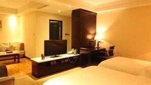 A hotel room with a large bed, a TV, a desk, and a chair. - Bandao Mingzhu Hotel (Zhaoqing)