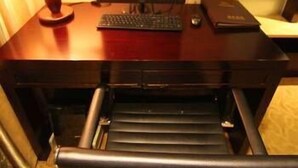 A wooden desk with a computer setup including a monitor, keyboard, and mouse. - Bandao Mingzhu Hotel (Zhaoqing)
