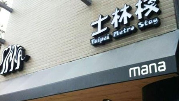 Un edificio con letreros que indican "Taipei Metro Stay" y "mana".