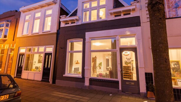A two-story building with large windows and a door, likely a commercial establishment. - Puur Geluk (Groningen)
