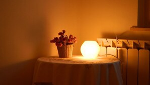 A table with a basket of flowers and a glowing light source. - Bed & Roses (Montesilvano)