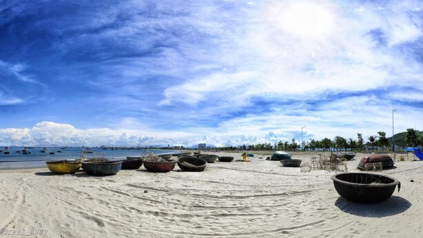 Ein Strand mit mehreren Booten und einem sandigen Ufer.