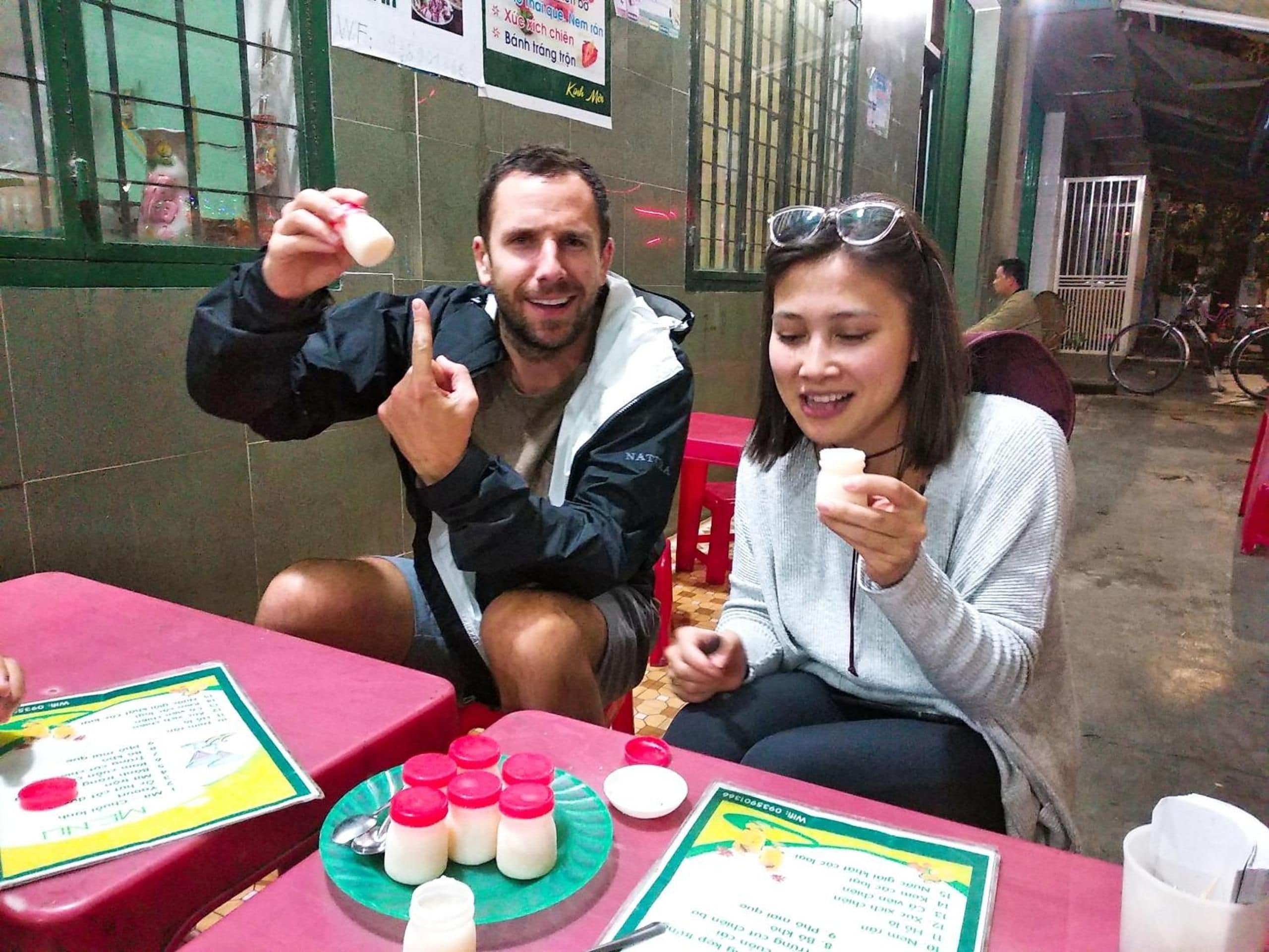 Two people seated at a table with a menu and food items.