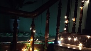 Eine Treppe mit Holzbalken und Lichterketten.