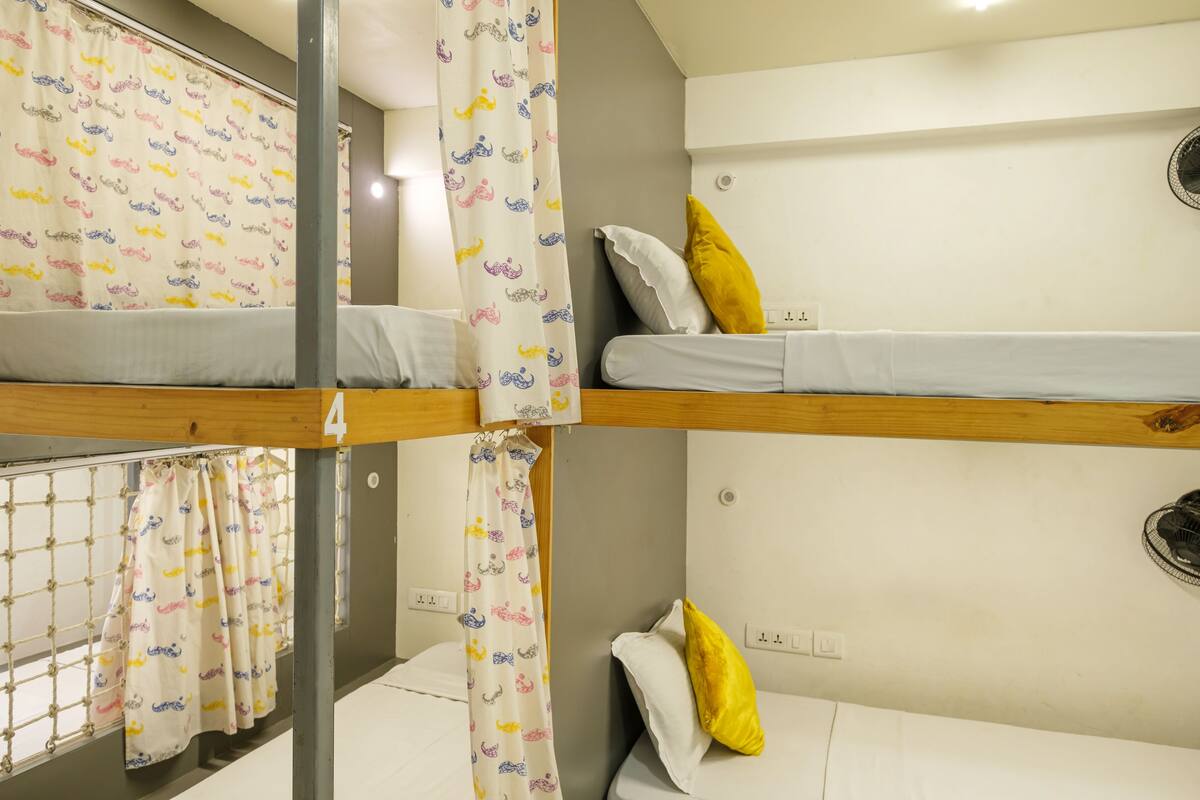 A bunk bed room with a curtain featuring a pattern of animals.