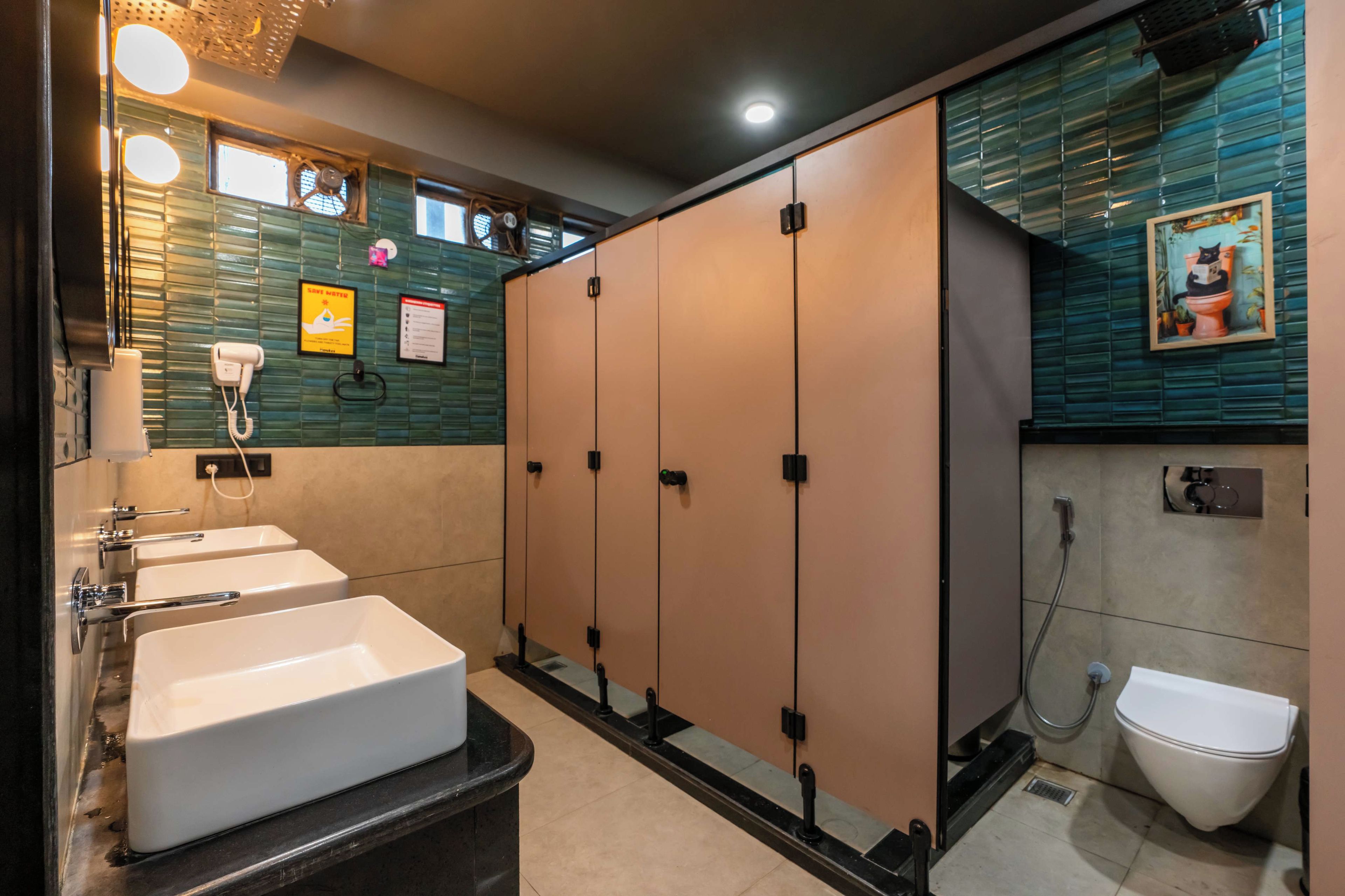 A modern bathroom with two sinks, a toilet, and a shower.