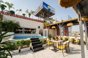 Uma área de piscina no terraço com mobiliário de exterior e uma placa com 'The7'.