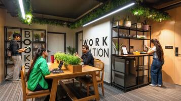 Un espacio de trabajo moderno con una mesa de madera, sillas y una estantería.
