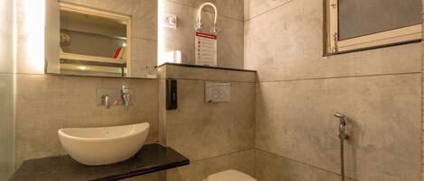 A bathroom with a white sink, a toilet, and a shower.