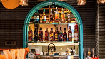 Un bar con varias botellas de licor y copas en estanterías.